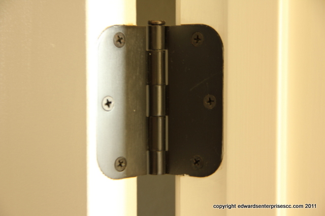 A door hinge under repair at a residence.