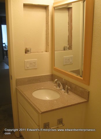 Residential Remodel: bathroom work in progress including new countertop, faucet and mirror, and medicine cabinet removal.