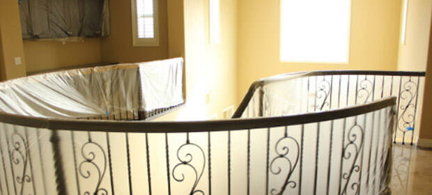 Circular stairway railing, draped in translucent plastic