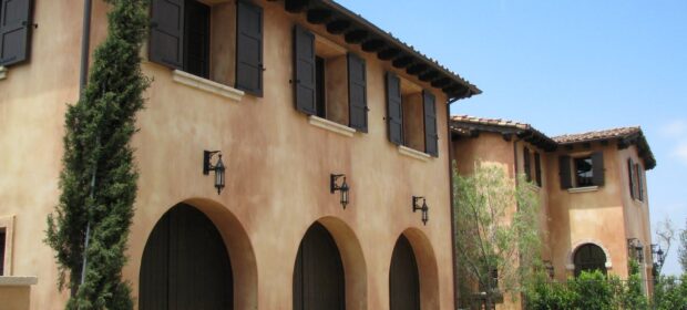 Front of two story Spanish-style home with smooth stucco finish