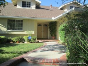 Path leading to front of house with shrubs to one side