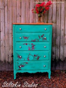Dresser painted aqua, distressed and flowers painted on the front