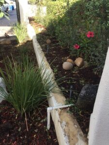 Stucco retaining wall in garden with sprinkler system