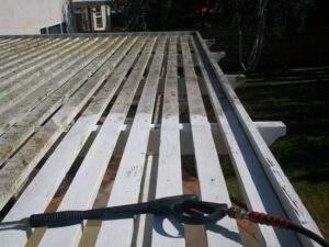 Top of pergola, partially pressure washed. Beneath the thick dirt is the clean white paint job