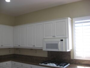 Kitchen with white cabinets being remodeled, after wallpaper removed