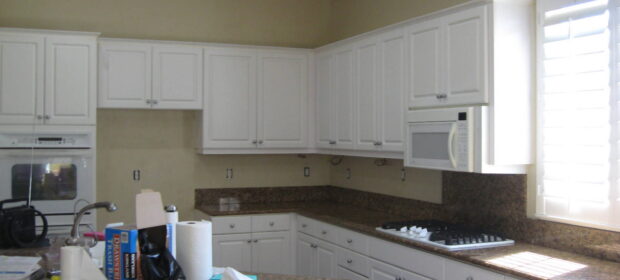 Kitchen with white cabinets being remodeled, after wallpaper removed