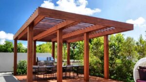 Wooden pergola over an outdoor table and barbecue grill