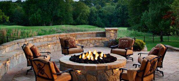Patio with six soft seat chairs surrounding a fire pit