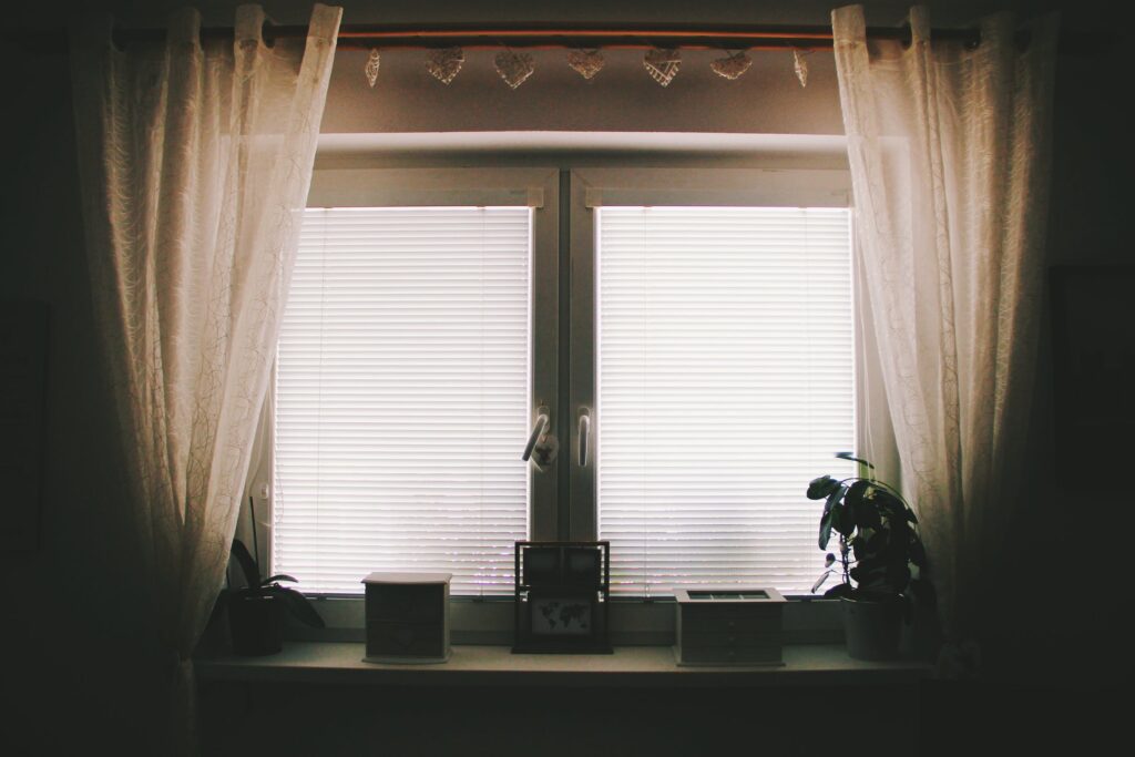 Subdued light through the curtains and blinds of a window