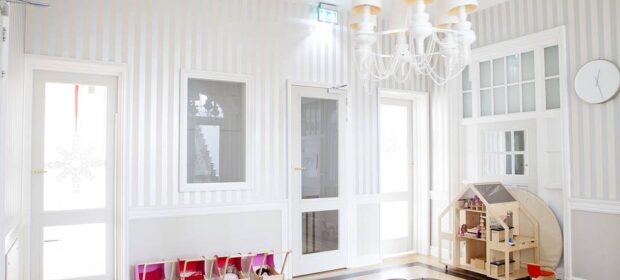 Kids' playroom, minimal but elegant, with wooden toys neatly lined against the walls