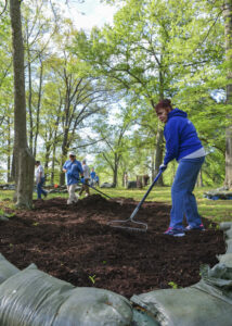 Peope spreading compost on the ground