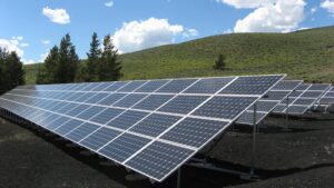 Solar panels with a grassy hill in the background