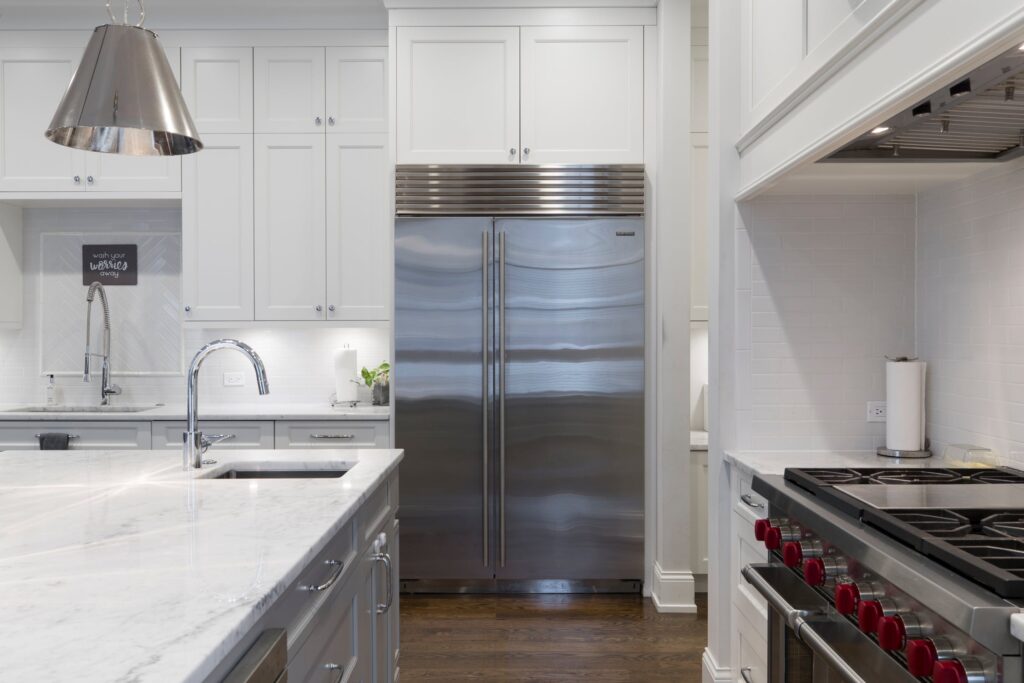 Stainless steel refrigerator in modern, white kitchen