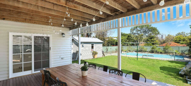 Long wood table on back patio under patio cover