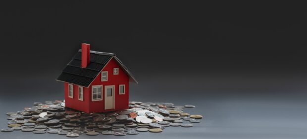 Tiny house on a pile of coins