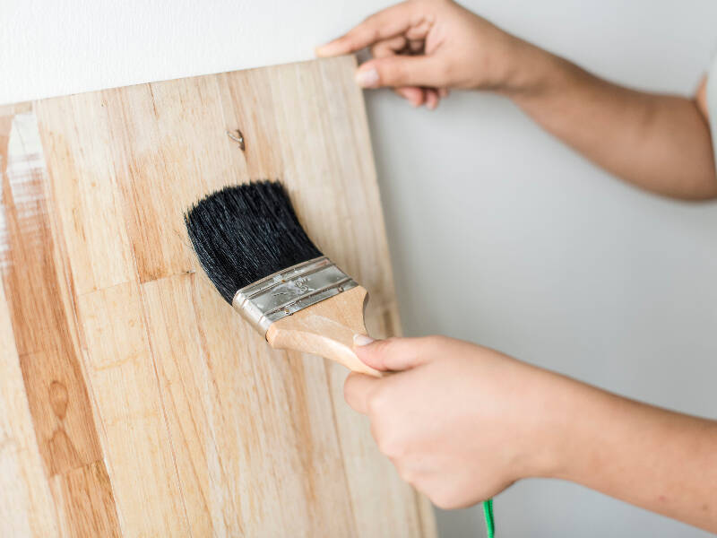 paint brush varnishing some wood