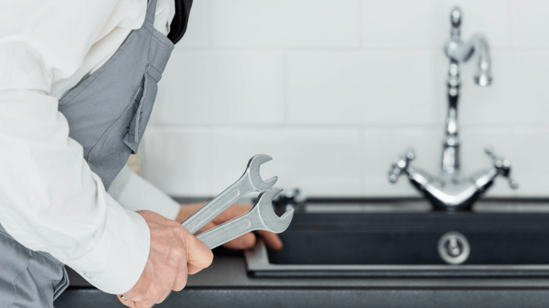 Image of a man preparing to work on a kitchen faucet