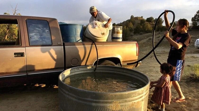 Image of people filling a cistern from a truck