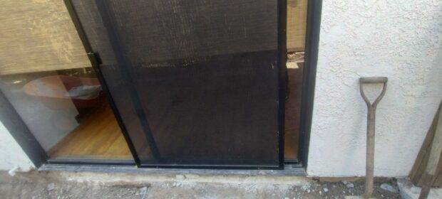 A screen door in need of repair at a work site.