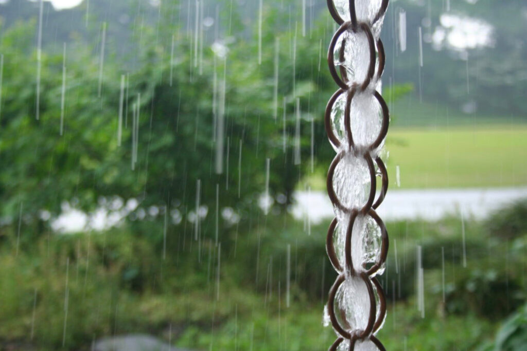A rain chain with rain running down it.